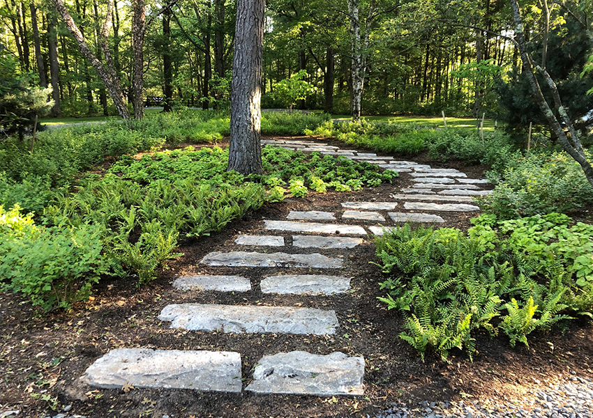 An inviting stone pathway through the landscape – great design using antique stone!