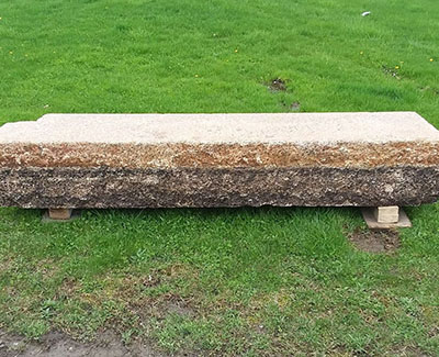 Large, rustic, reclaimed stone with patina used as a bench
