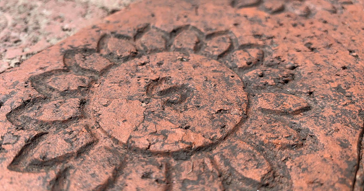 Antique stamped sidewalk brick paver.