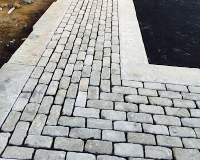 A stunning driveway border created from old granite cobblestones and reclaimed curbing