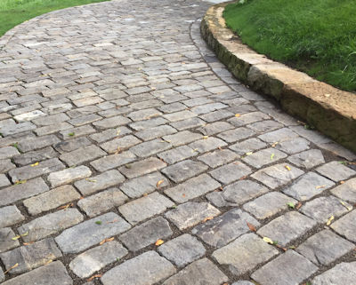 Reclaimed stone laid on side for a rustic cobblestone driveway