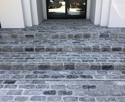 Entry steps created using salvaged regulation granite cobbles