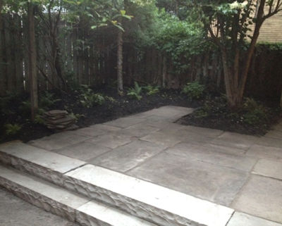 An urban reclaimed stone patio behind a restored historic home